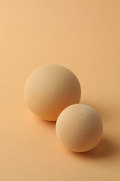 Photo of Two textured balls on beige background, closeup