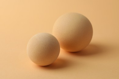 Photo of Two textured balls on beige background, closeup