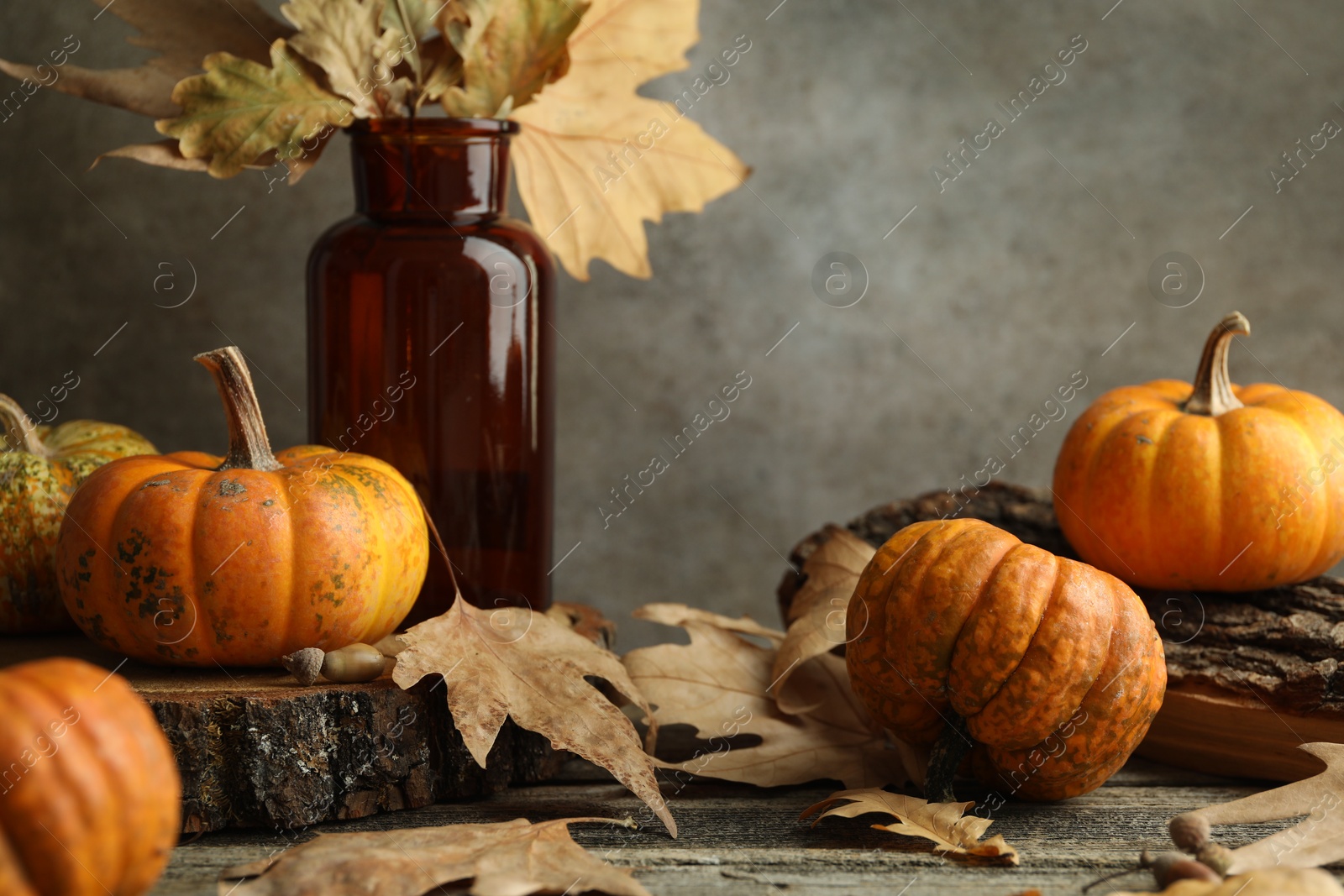 Photo of Fresh pumpkins and dry leaves on wooden table