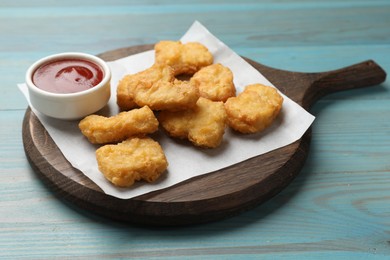 Photo of Delicious chicken nuggets and ketchup on wooden table, closeup