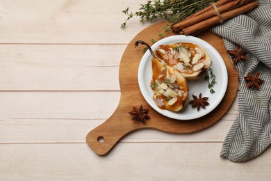 Photo of Delicious pears with caramel sauce, almond flakes and spices on white wooden table, flat lay. Space for text