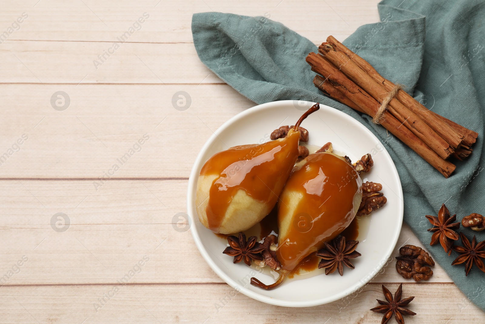 Photo of Delicious pears with caramel sauce and spices on white wooden table, flat lay. Space for text