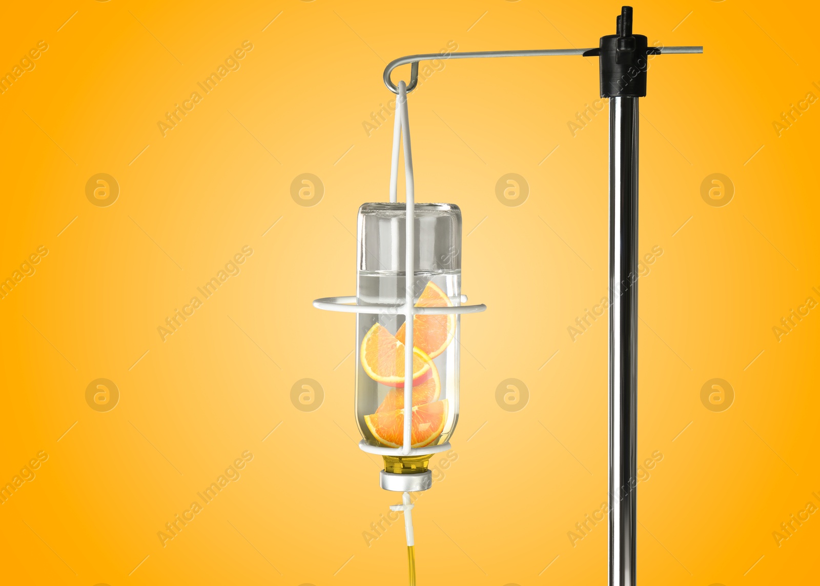 Image of Vitamin intravenous therapy. IV infusion set on orange background. Glass bottle with orange slices inside