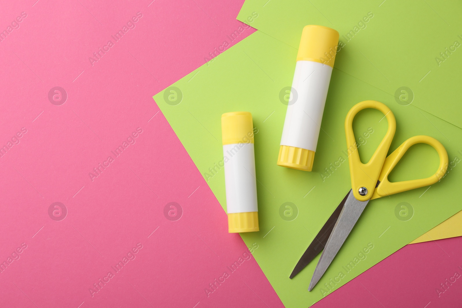 Photo of Glue, colorful paper and scissors on pink background, flat lay. Space for text