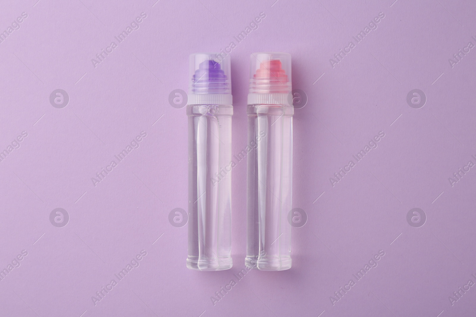 Photo of Transparent glue on violet background, flat lay