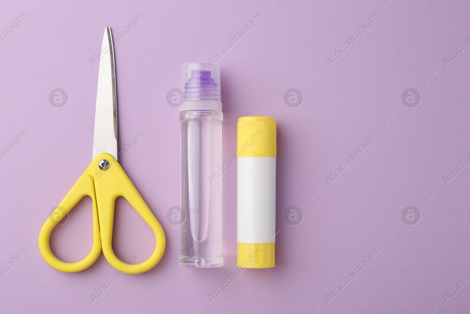 Photo of Glue and scissors on violet background, flat lay. Space for text