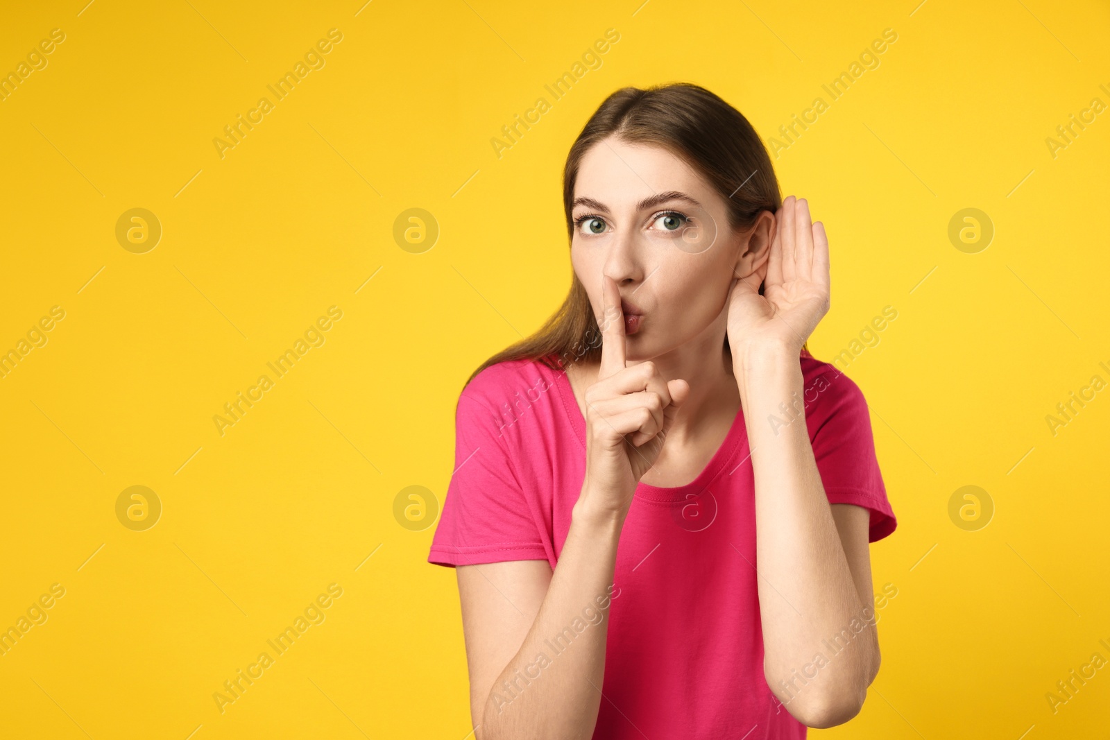 Photo of Woman showing hand to ear gesture on yellow background, space for text