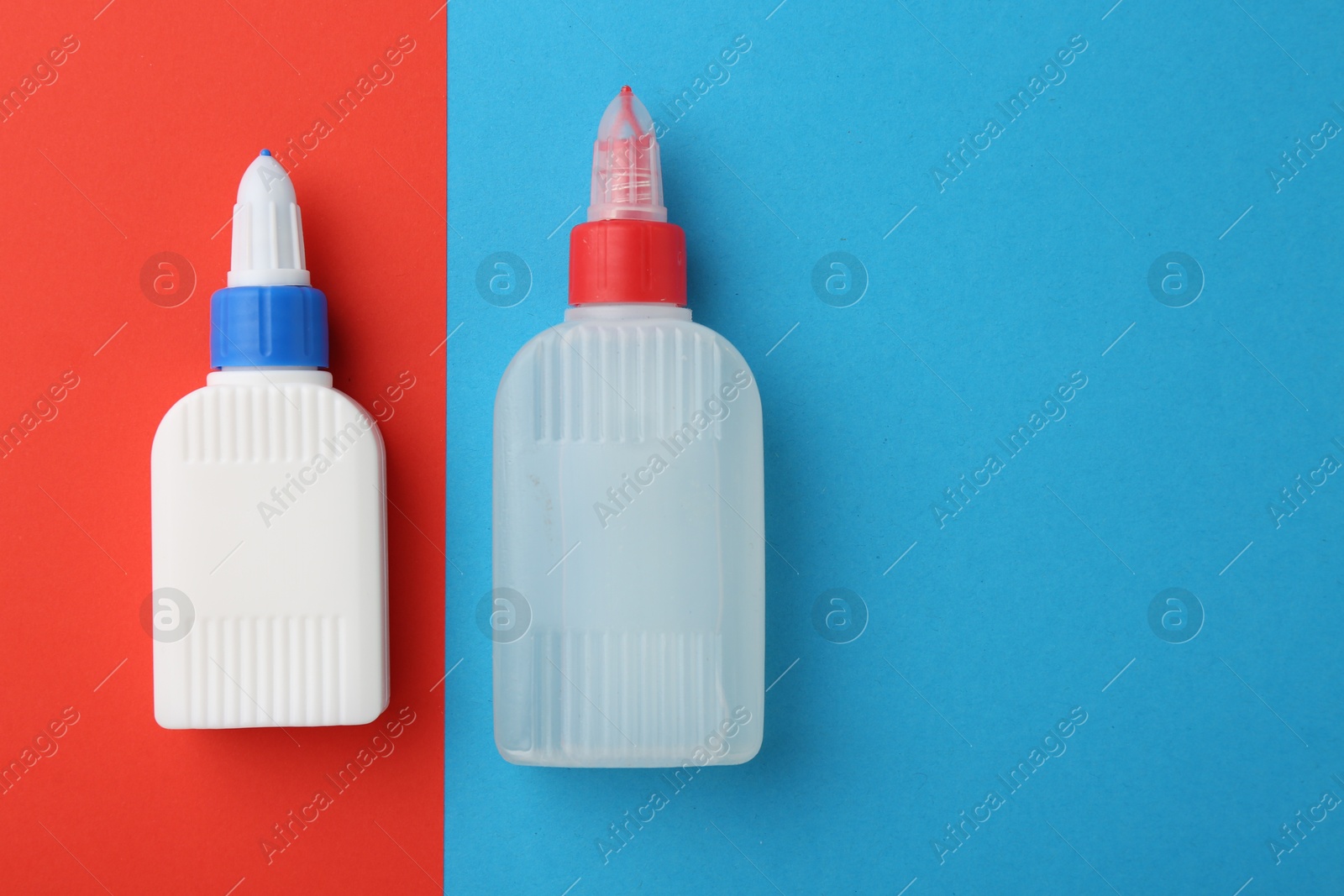 Photo of Bottles of glue on color background, flat lay. Space for text