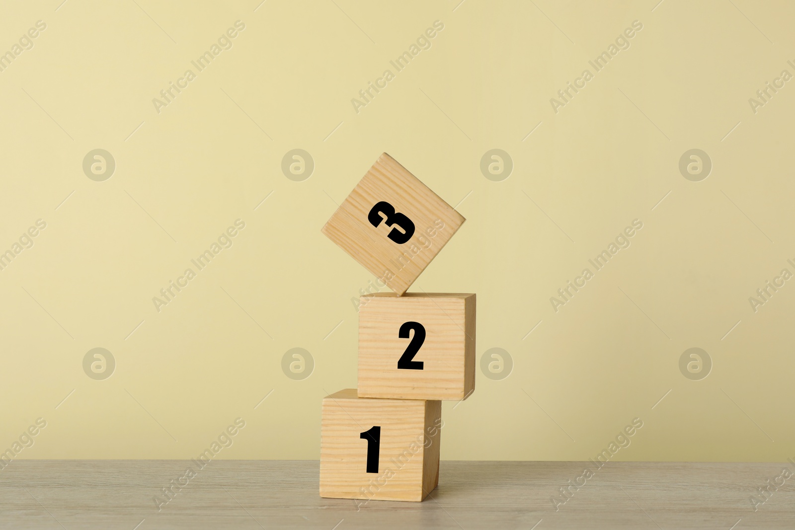 Image of Wooden cubes with numbers 1, 2, 3 on beige background. Step-by-step concept