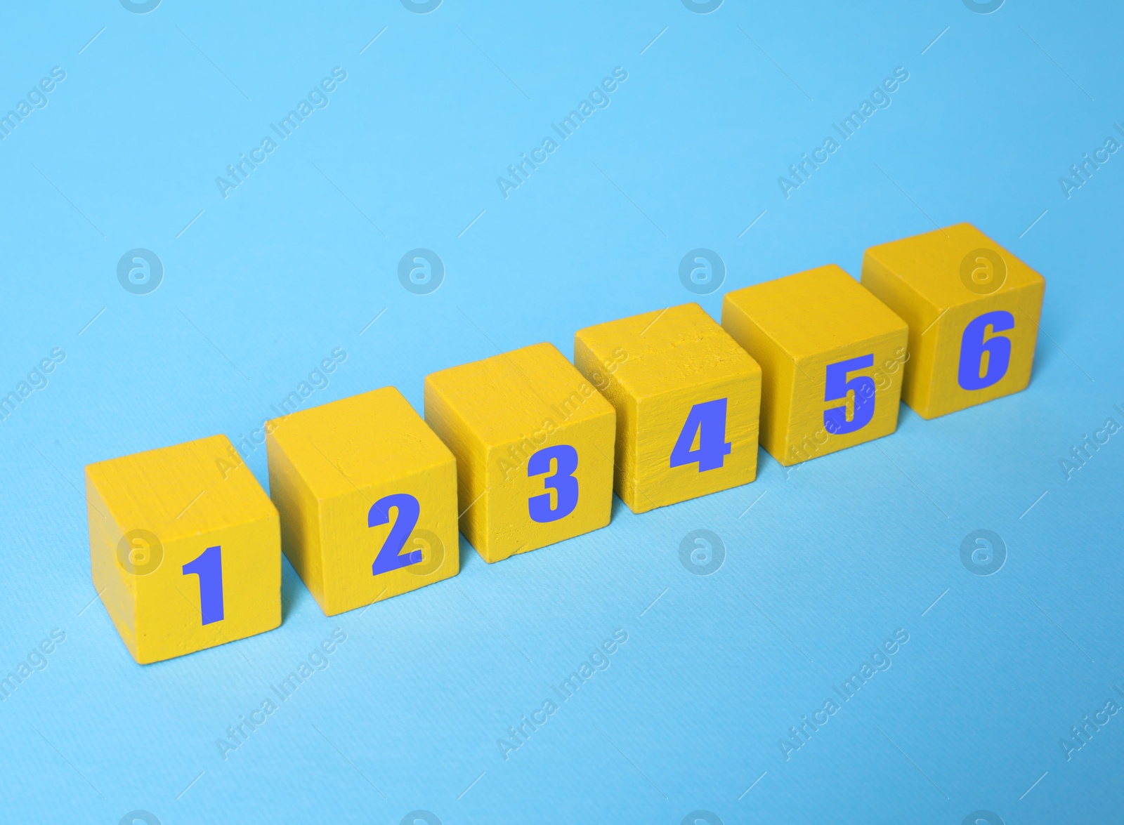 Image of Yellow numbered cubes on light blue background. Step-by-step concept