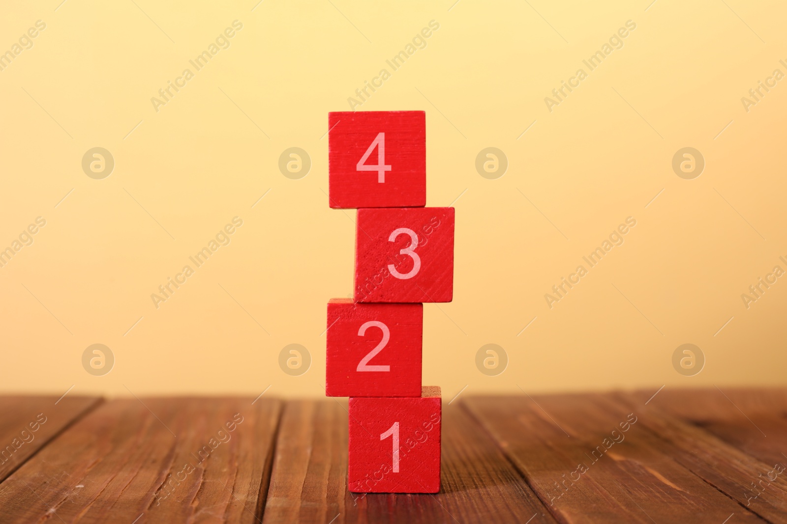 Image of Stacked red cubes with numbers from 1 to 4 on beige background. Step-by-step concept