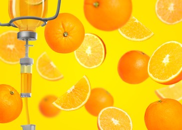 Image of Vitamin intravenous therapy. IV infusion set and falling oranges on yellow background