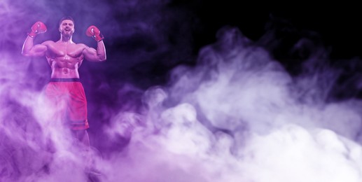 Man in boxing gloves celebrating victory in smoke on black background, low angle view. banner design with space for text