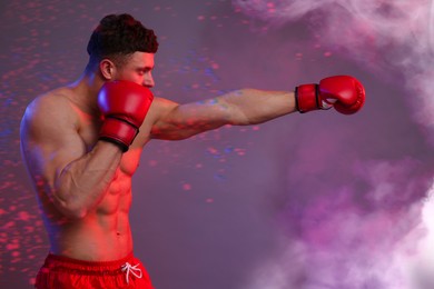 Boxer training in smoke on color background