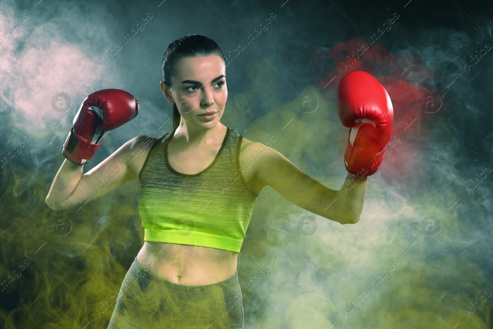 Image of Boxer fighting in color smoke under spotlights