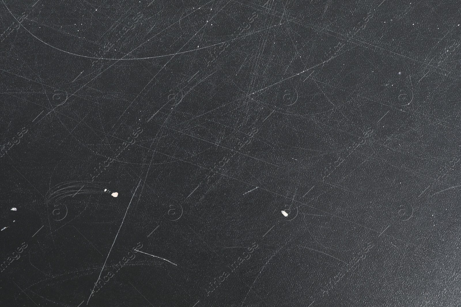 Photo of Texture of scratched black surface as background, closeup