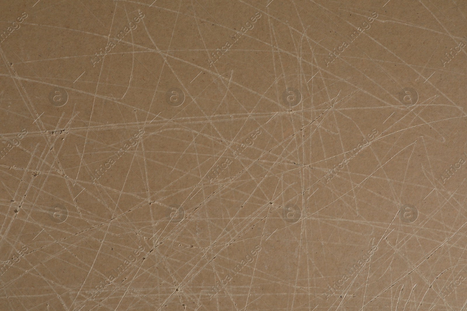 Photo of Old fiberboard with scratches as background, closeup