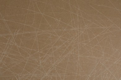 Photo of Old fiberboard with scratches as background, closeup