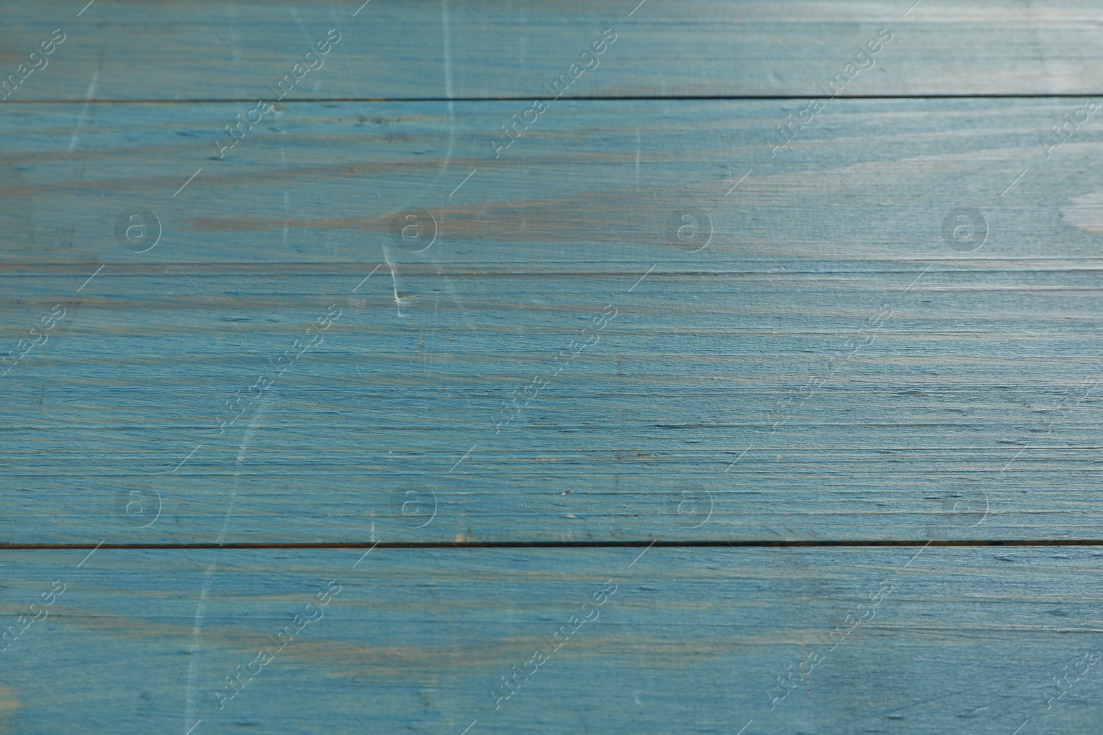 Photo of Old light blue wooden surface with scratches as background, closeup