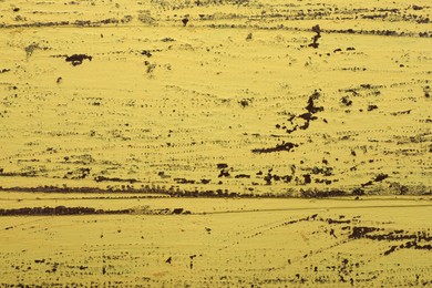 Photo of Old yellow wooden surface with scratches as background, closeup