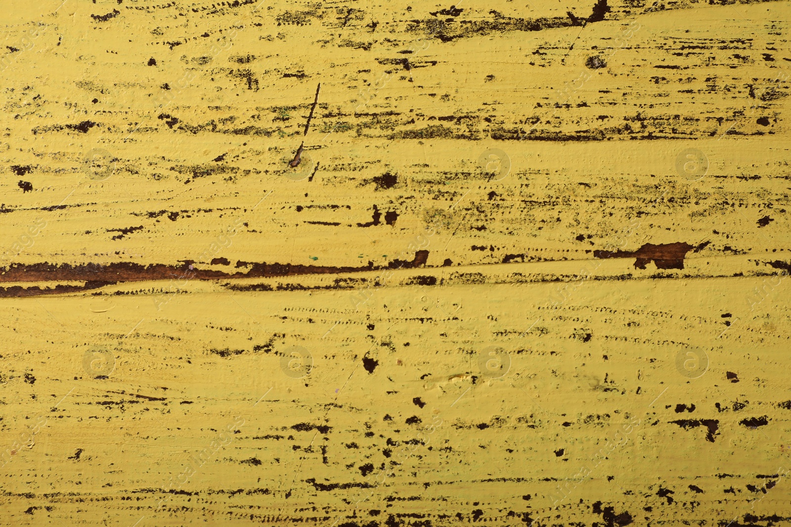 Photo of Old yellow wooden surface with scratches as background, closeup