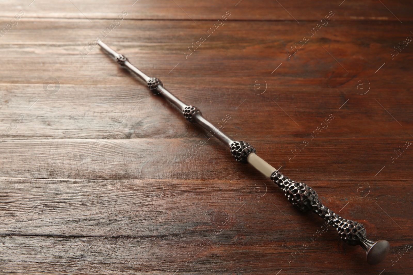 Photo of One old magic wand on wooden table, closeup