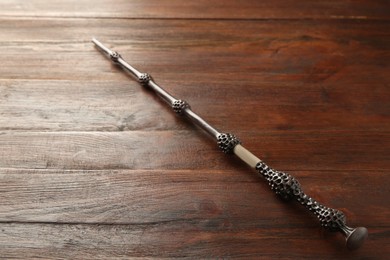 One old magic wand on wooden table, closeup