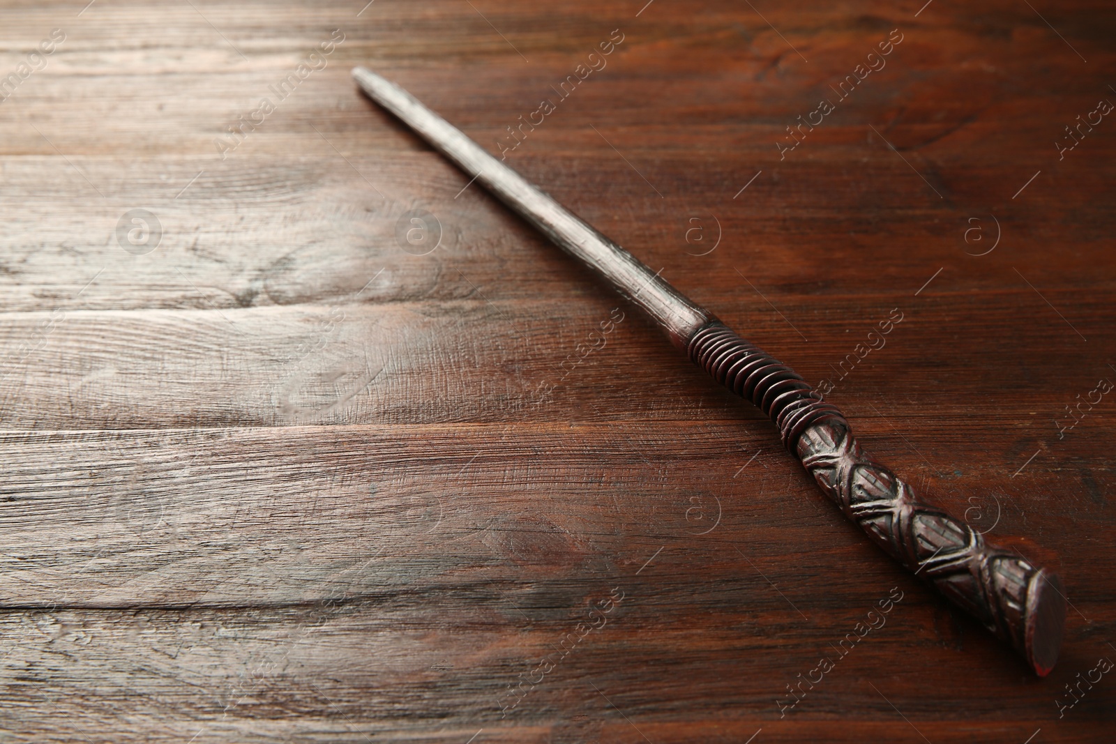 Photo of One old magic wand on wooden table, closeup. Space for text