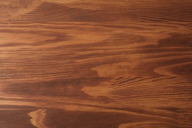 Photo of Applying walnut wood stain. Texture of wooden surface as background, top view