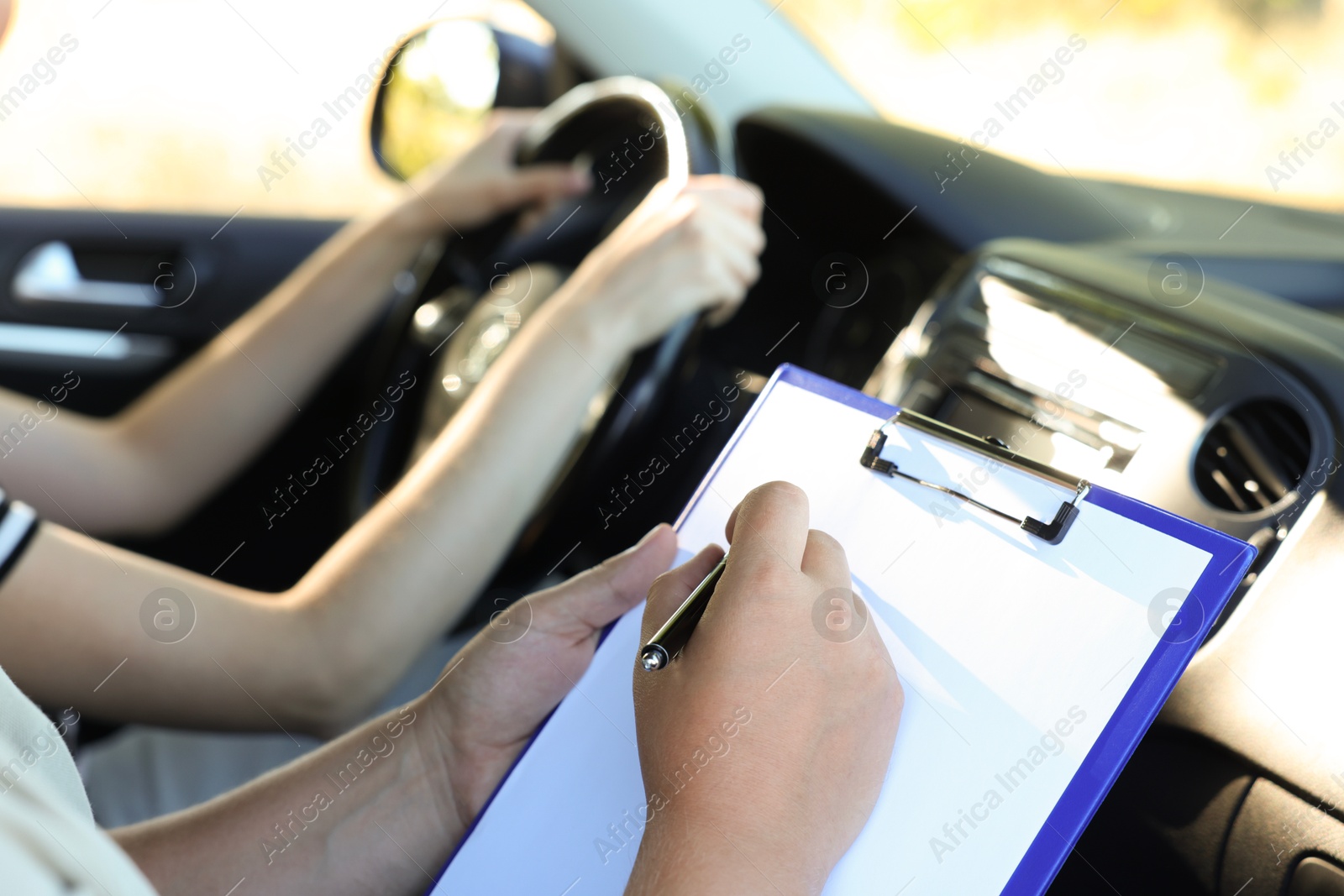 Photo of Driving school. Student passing driving test with examiner in car, closeup