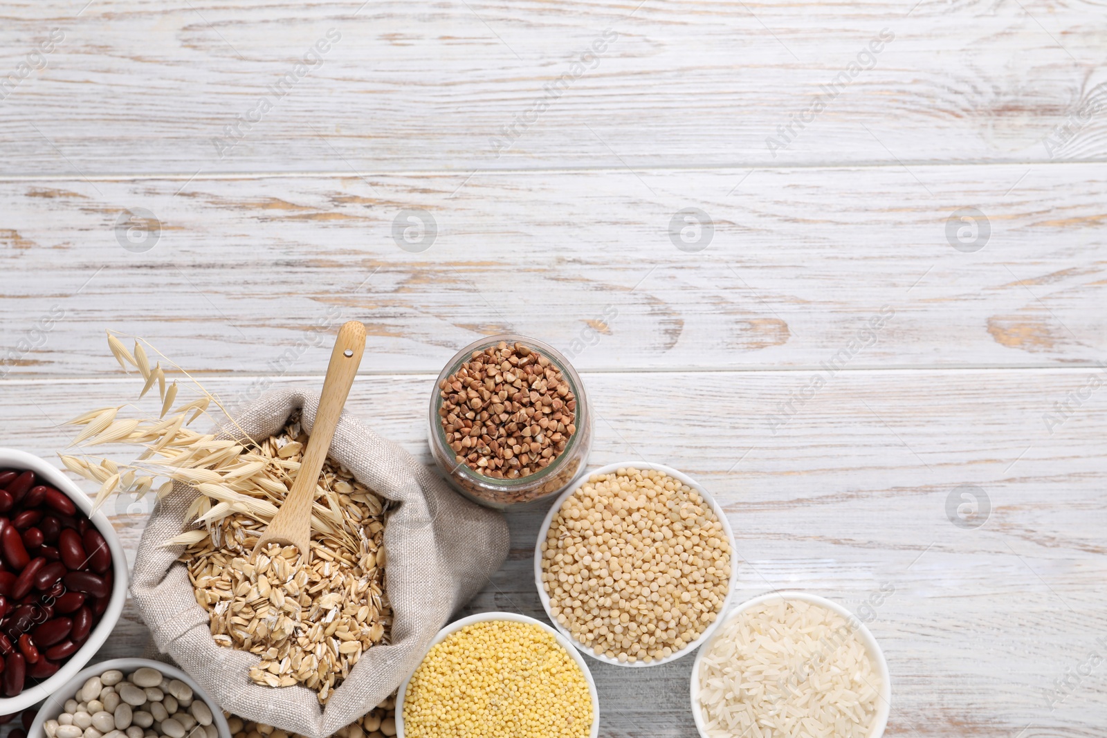 Photo of Different types of legumes and cereals on white wooden table, flat lay. Space for text