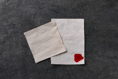 Photo of Old letters with wax stamp on grey table, top view