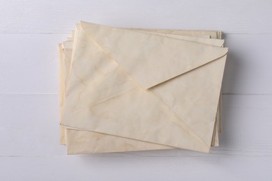 Photo of Stack of old letter envelopes on white wooden table, top view