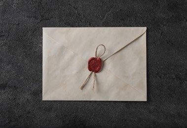 Photo of Old letter envelope with wax stamp on grey table, top view