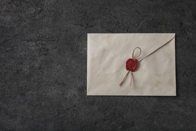 Photo of Old letter envelope with wax stamp on grey table, top view. Space for text