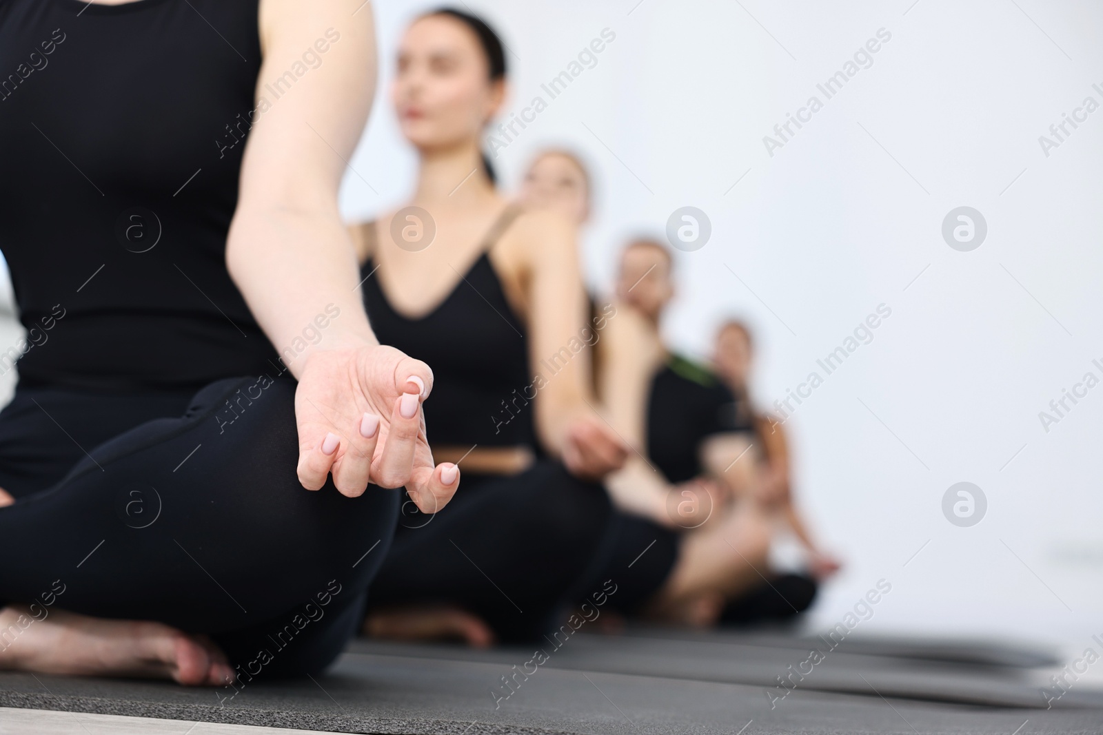 Photo of Group of people meditating in yoga class, closeup. Space for text