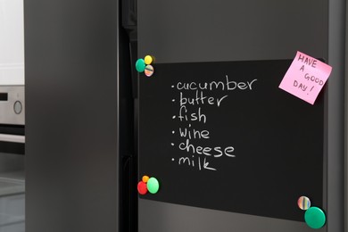 Magnetic board with shopping list and note on refrigerator in kitchen