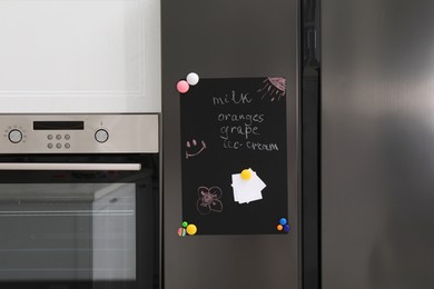 Magnetic board with shopping list and notes on refrigerator in kitchen