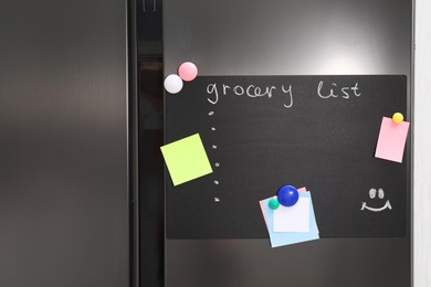 Photo of Magnetic board with grocery list and notes on refrigerator in kitchen