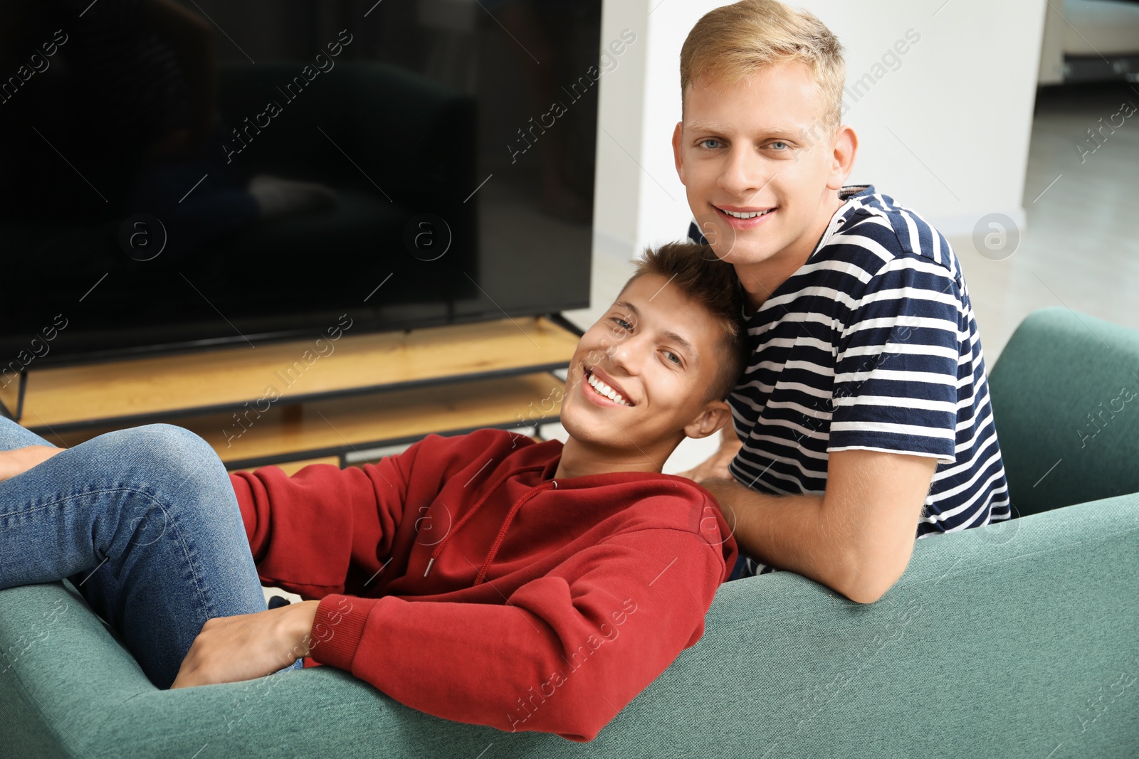 Photo of Family portrait of happy brothers on sofa at home