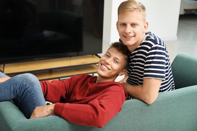 Family portrait of happy brothers on sofa at home