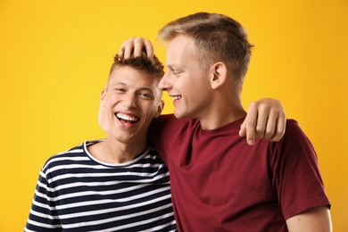 Photo of Portrait of happy brothers on orange background