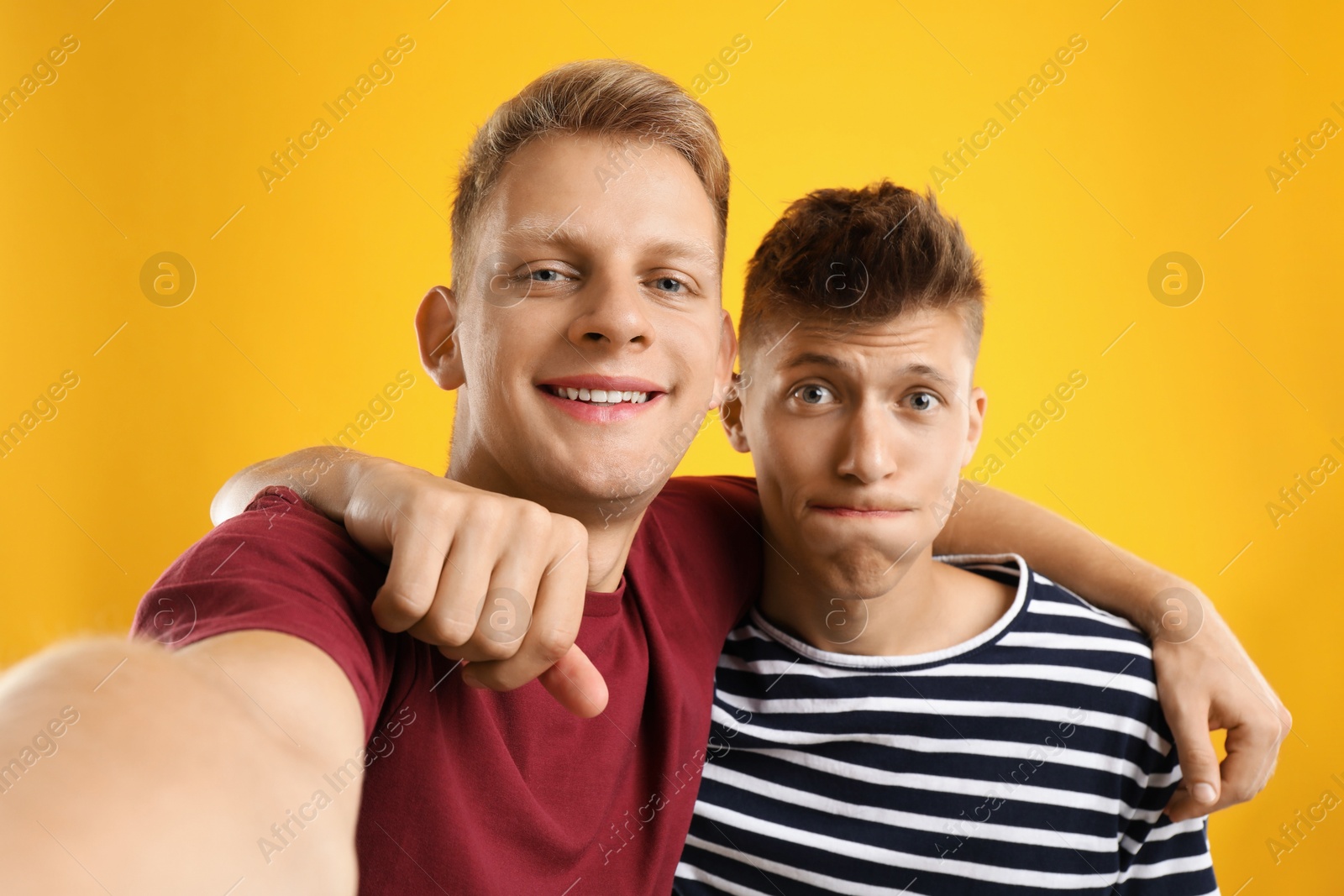 Photo of Funny brothers taking selfie on orange background