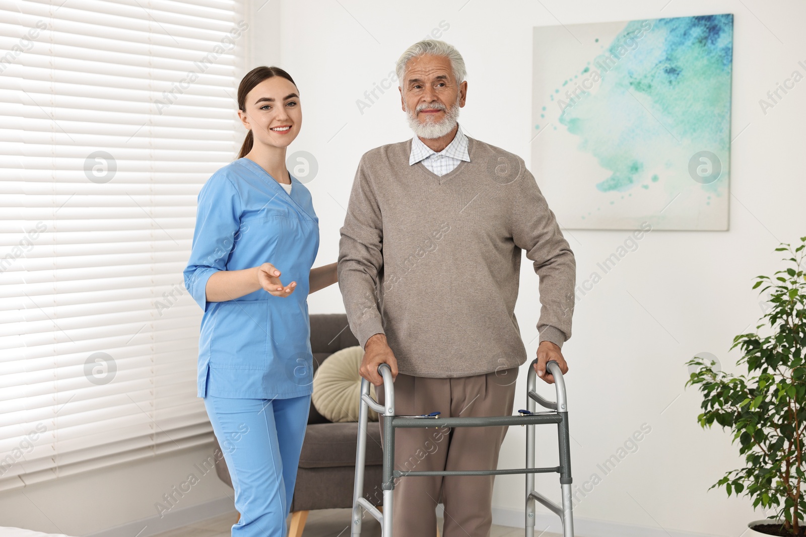 Photo of Nurse helping senior man with walking frame in clinic