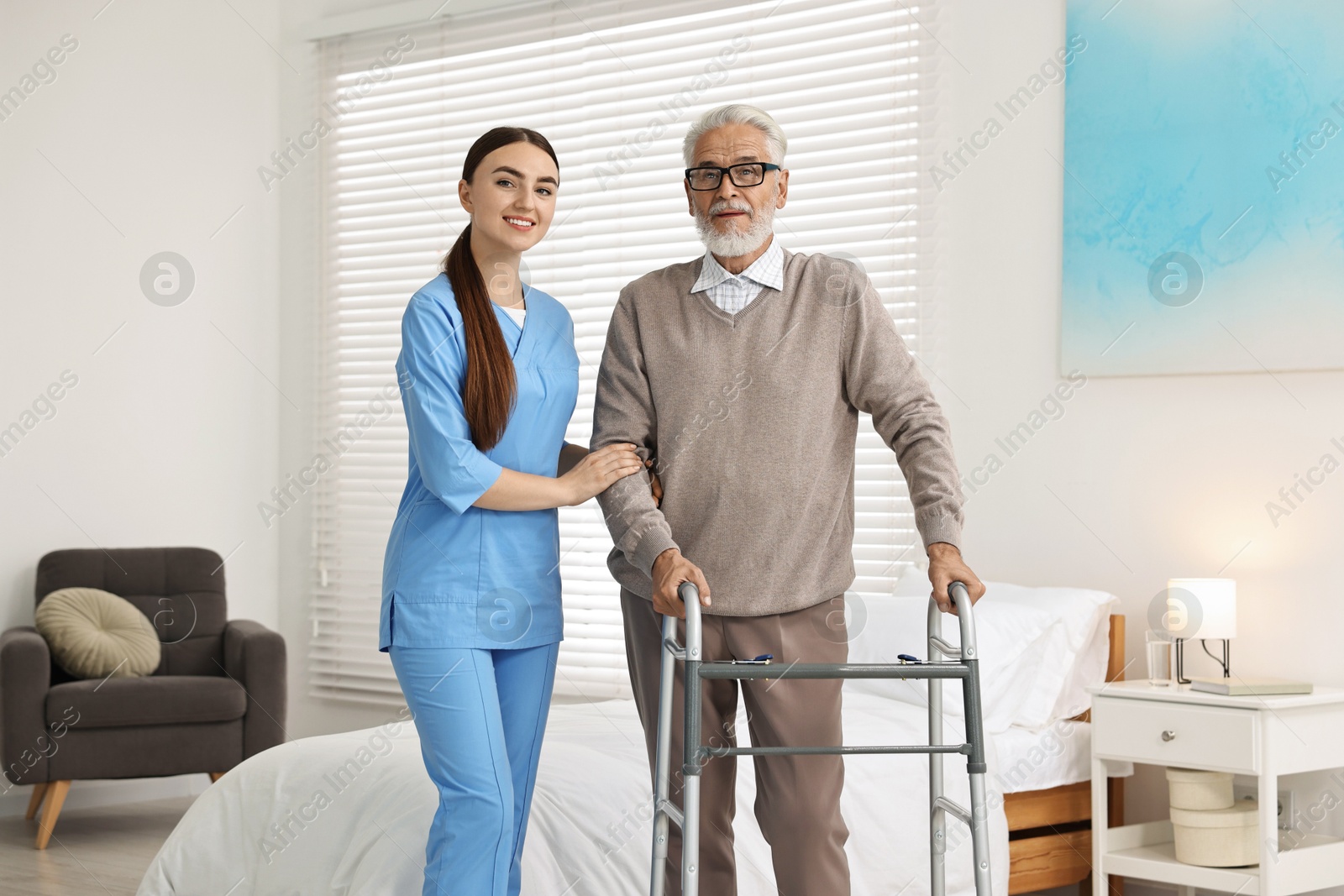 Photo of Nurse helping senior man with walking frame in clinic