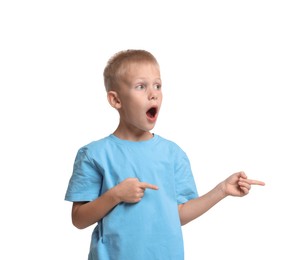 Scared little boy pointing at something on white background