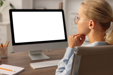 Woman working with computer monitor at table in office. Mockup for design