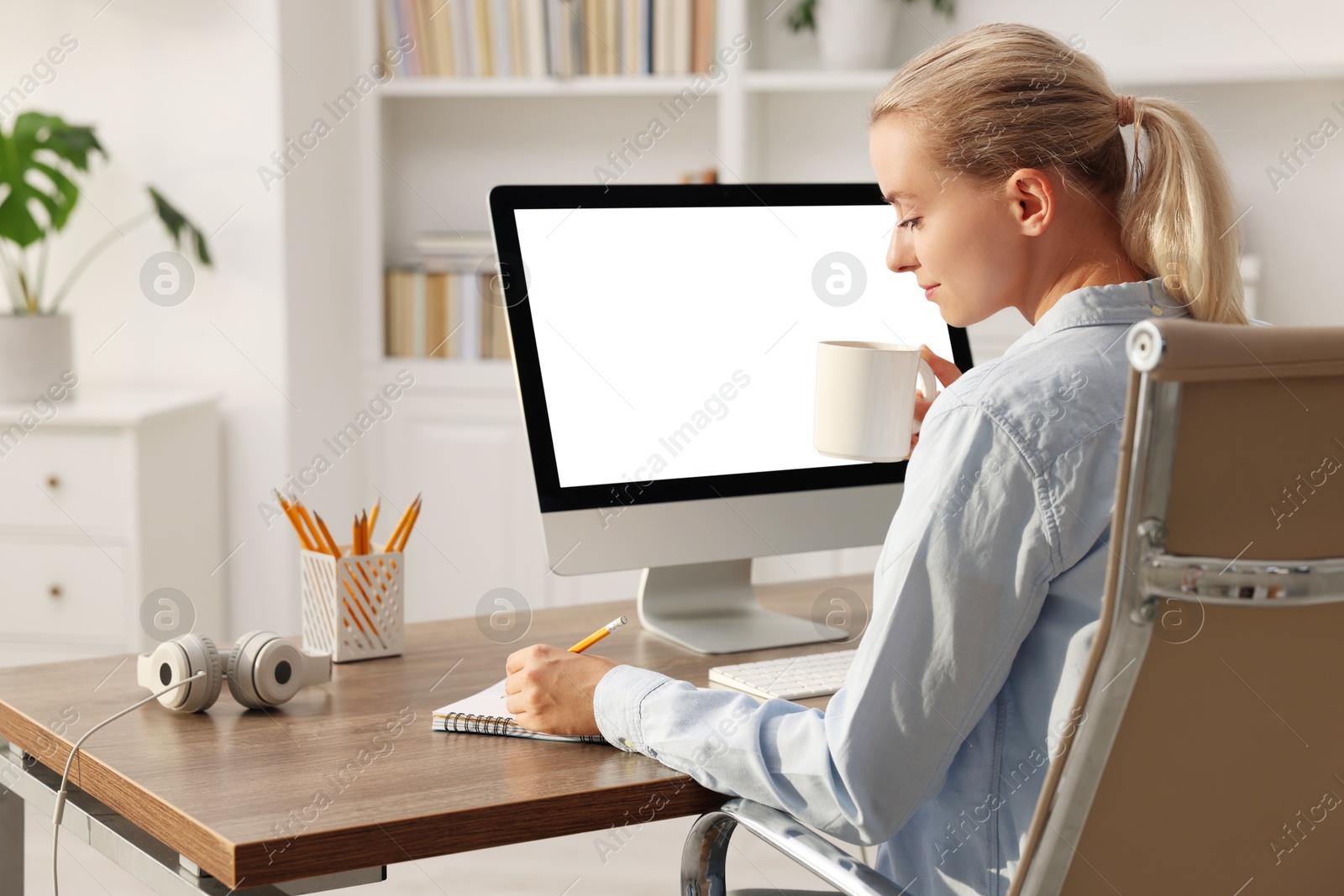 Photo of Woman working at table with computer monitor in office. Mockup for design