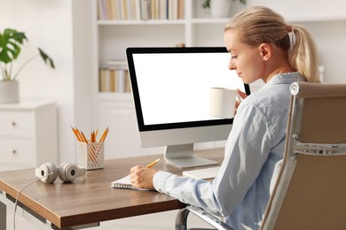 Woman working at table with computer monitor in office. Mockup for design