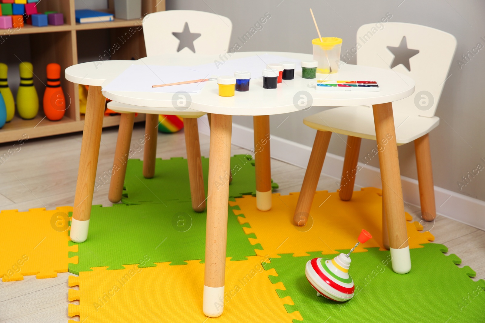 Photo of Beautiful kid's room interior with toys, paints and stylish furniture